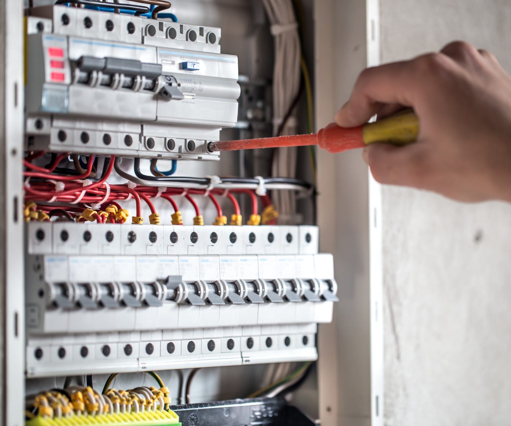 man electrical technician working switchboard with fuses installation connection electrical equipment close up scaled e1717098479662